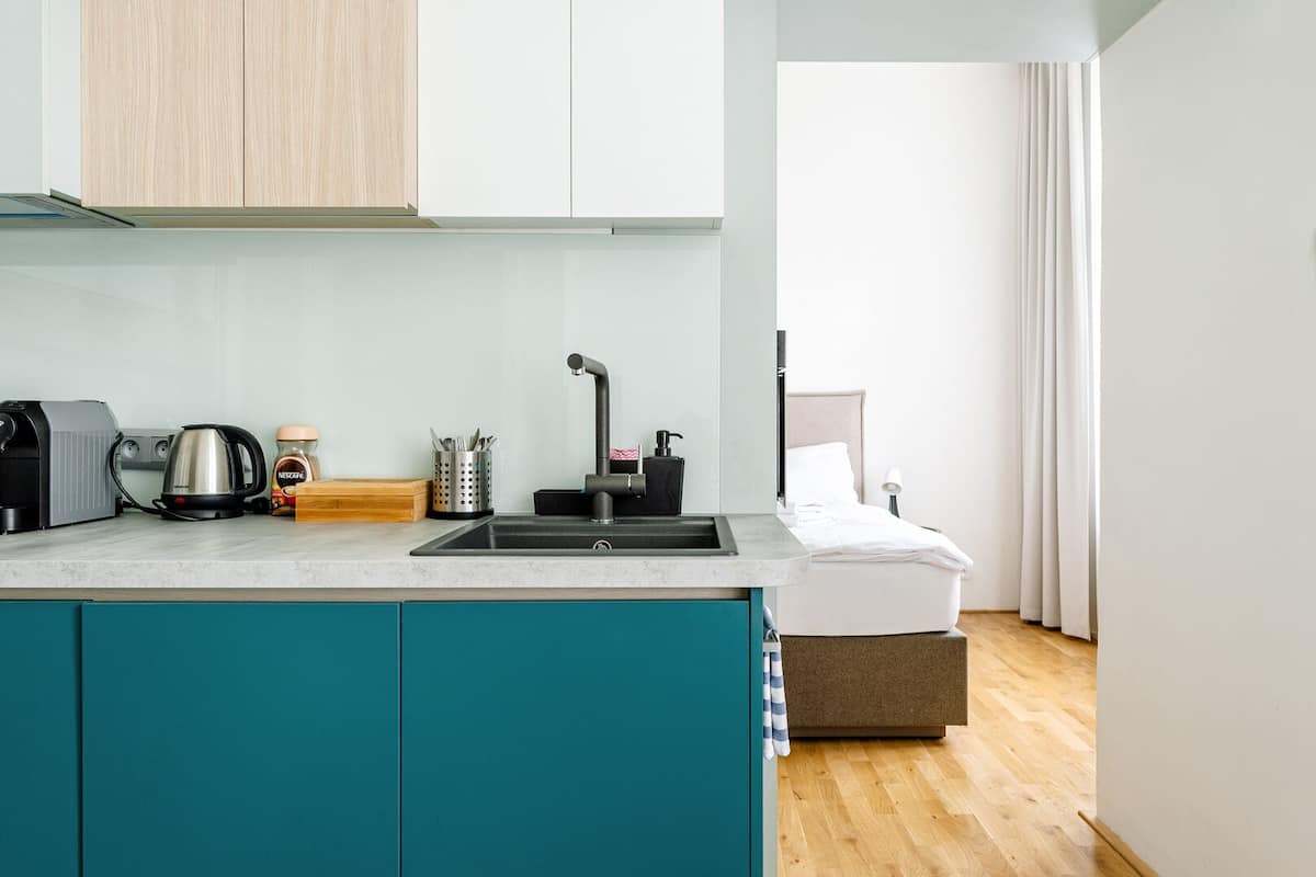 A modern kitchenette with a built-in sink, a coffee maker, and a kettle.