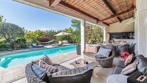A covered outdoor area with a pool, wicker furniture, and a kitchen area. - DIANE By Terry's Homes (Cannes)