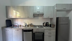 Eine moderne Küche mit Edelstahlgeräten, Granit Arbeitsplatten und hellen Schränken.