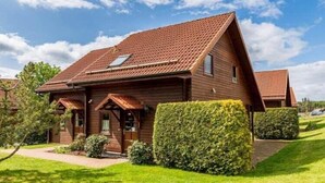 Una casa in legno con tetto spiovente e una piccola finestra.