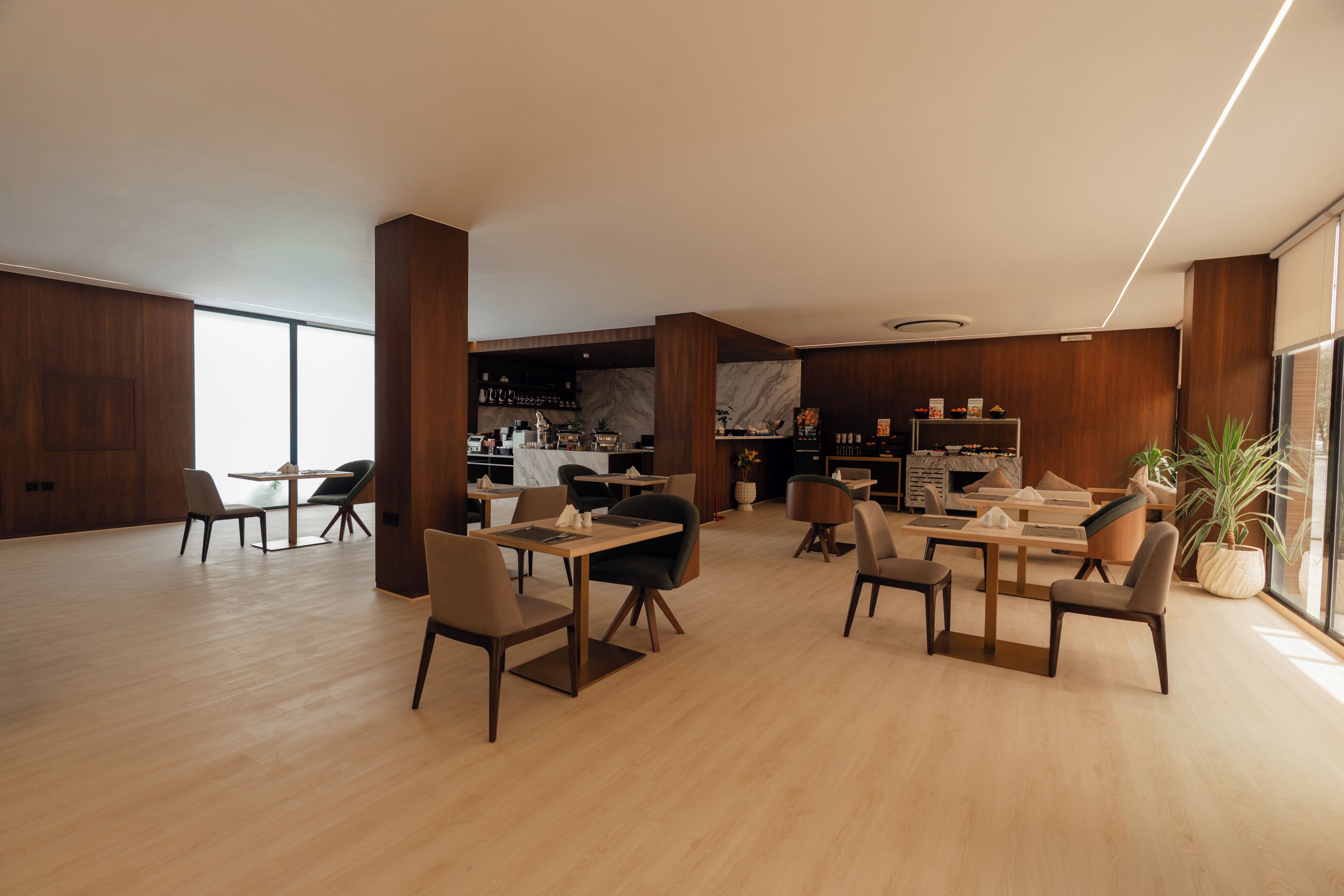 Un interior espaiós i modern amb terres de fusta i diferents combinacions de seients, incloent taules i cadires.
