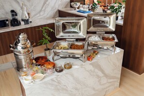 Montaje de bufé con varios recipientes de comida y salsas.