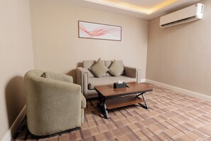 A modern living room with a sofa, armchair, and a coffee table.