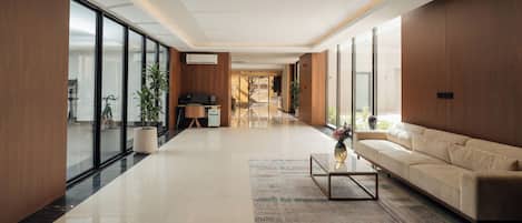 A spacious living area with a sofa, coffee table, and a large window providing natural light.