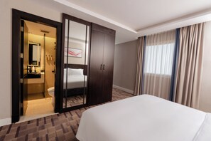 A hotel room with a bed, a wardrobe, a bathroom, and a window with curtains. - Howard Johnson by Wyndham Riyadh Al Nasiriyah (Riyadh)