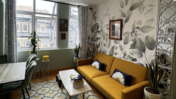 A living room with a sofa, a coffee table, a patterned rug, and a dining area with chairs and a table. - 2 bedroom apartment  (London)