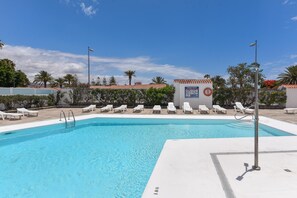 Piscina con sillas de descanso y un flotador.