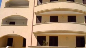 Un edificio de varios pisos con balcones y ventanas en arco.