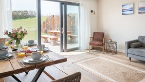A dining area with a table set for breakfast, a sofa, and a chair.