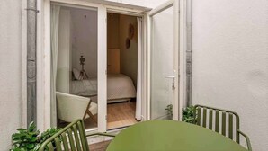 Ein Zimmer mit Bett, Sessel und Tisch.