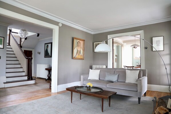 Un salon avec un canapé gris, une table basse et un escalier.