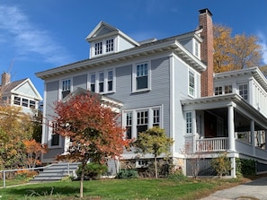 A large, two-story house with a prominent front porch and a brick chimney.