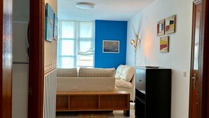 A hallway with a sofa, a black cabinet, and a blue wall. - Preciosa Vivienda Para Vacaciones a 50m de la Playa de Altar (Barreiros)