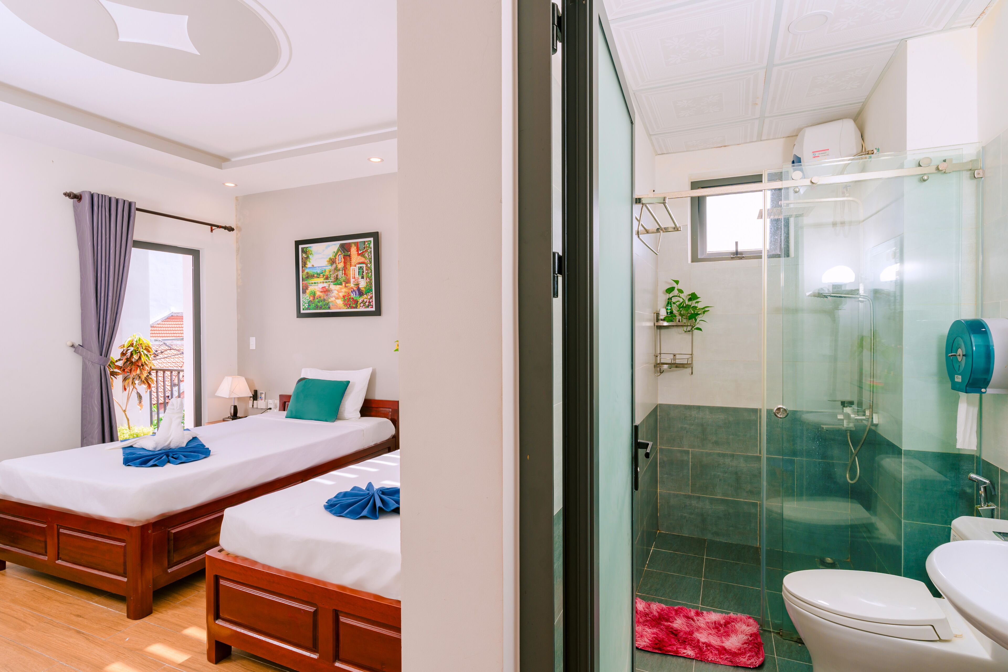 A hotel room with two wooden beds, a glass shower enclosure, and a white toilet.