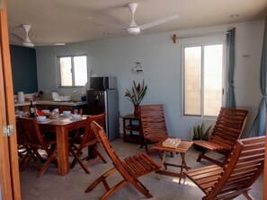 A dining area with wooden furniture, a refrigerator, and a microwave. - A la orilla del mar ok2 (Chuburná)