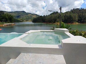 A hot tub with a view of a lake and mountains. - Casa Linda Guatapé (Guatapé)