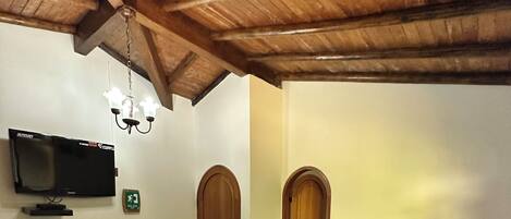 Una habitación con una cama, un televisor y dos puertas de madera.