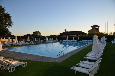 Una piscina al aire libre de temporada, sombrillas. Golf Hotel Castelconturbia