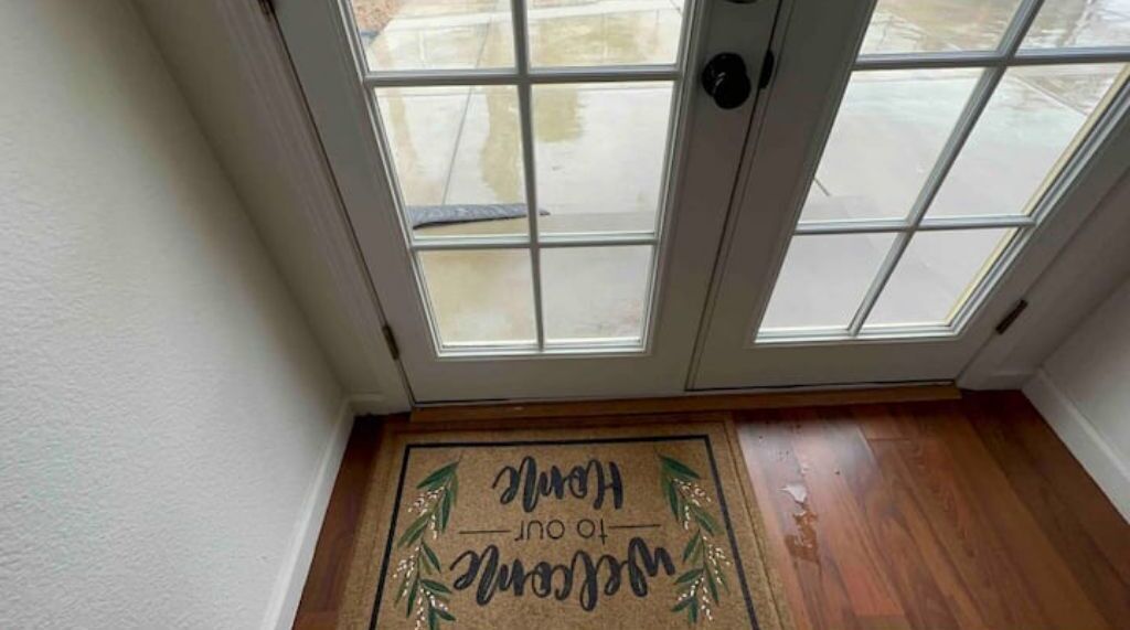 A wooden floor with a welcome mat that reads "Welcome Home."