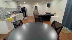 A compact living space with a kitchen, dining area, and a small seating area. - Private Guesthouse for 4 - EV, Pool, Kitchen, Fast Wi-Fi (Tracy)