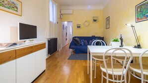 A compact living space with a kitchenette, a dining area, and a sofa. - Santa Reparata Flat by Mmega (Florence)