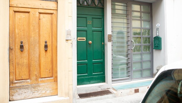 A building with two doors, one wooden and one green, with a window and a mailbox on the right. - Santa Reparata Flat by Mmega (Florence)