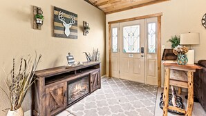 A cozy interior with a fireplace, wooden ceiling, and a door with decorative glass panels. - Northwoods Oasis close to Duluth - BOULDBERBELLE RETREAT (Saginaw)