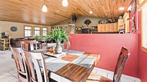A dining area with a wooden table, chairs, and a vase of plants. - Northwoods Oasis close to Duluth - BOULDBERBELLE RETREAT (Saginaw)