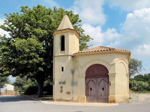 Une petite église isolée, dotée d’un clocher et d’une grande porte en bois.