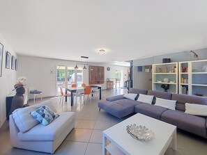 Un salon moderne avec un canapé, une table à manger et une bibliothèque.