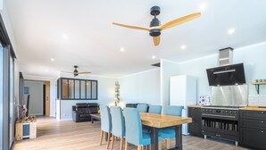 Una cocina moderna con comedor, que incluye una mesa de madera, sillas azules y una estufa negra.