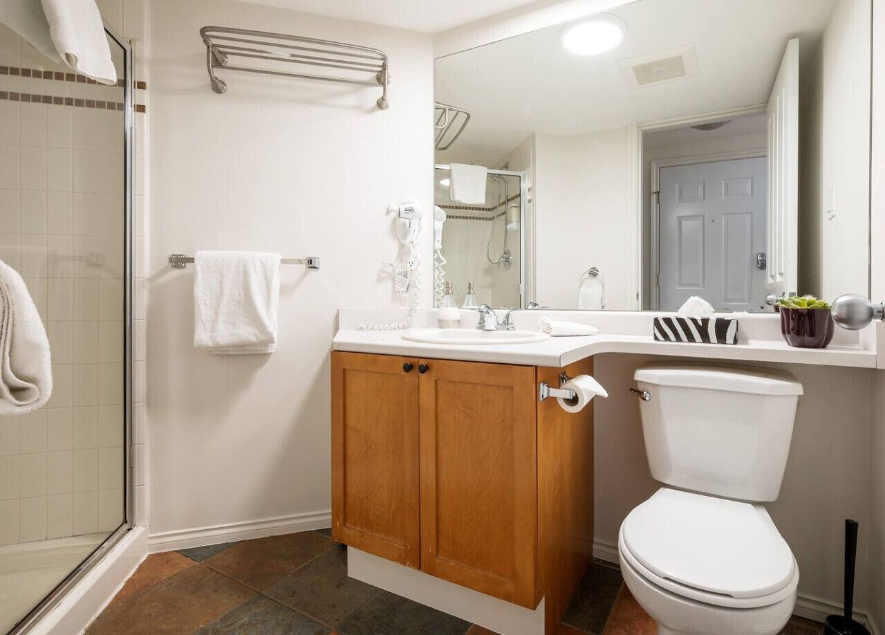 A bathroom with a shower, toilet, and sink.