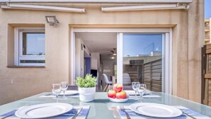 Une table à manger dressée avec des assiettes, des couverts et une plante en pot.