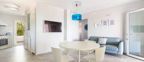 A modern kitchen with a built-in oven and a dining area with a round table and four chairs.