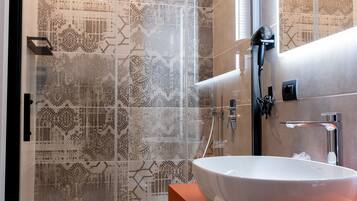 Habitación Deluxe | Baño | Regadera, regadera tipo lluvia, secadora de cabello, batas