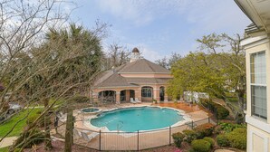 Una casa con piscina, patio cubierto y jardín.
