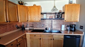Eine Küche mit Holzausstattung, einer Edelstahlspüle und einer Kaffeemaschine.