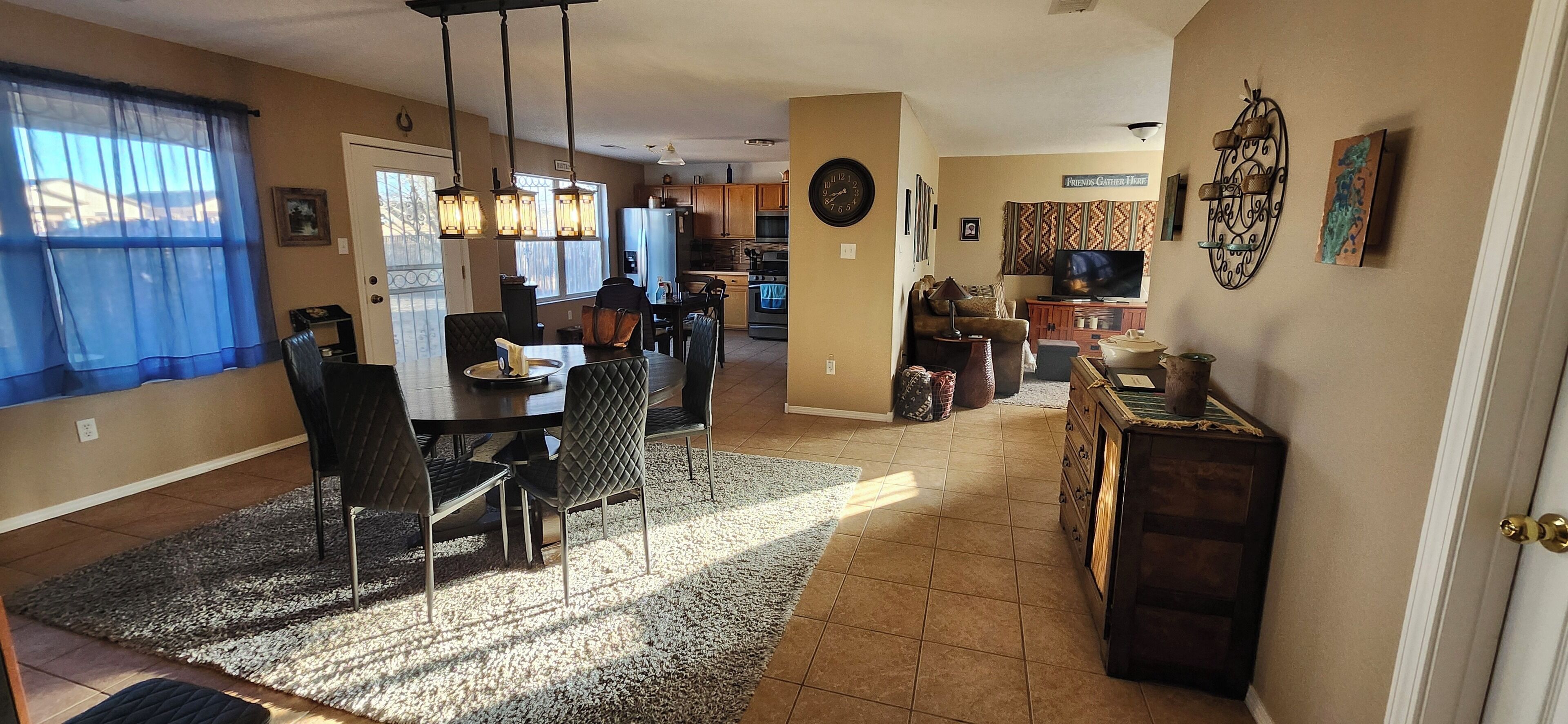 Un vaste salon comprenant un coin repas, une cuisine et un téléviseur.