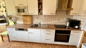 Una cocina moderna con microondas integrado, lavaplatos de acero inoxidable y lavavajillas.