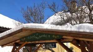 Una estructura de madera con un letrero que dice "P. Seckelnschaukel M" en un paisaje nevado al aire libre.
