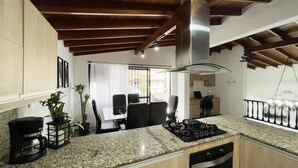 A kitchen with granite countertops, a stainless steel range hood, and wooden cabinets.