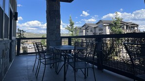 Ein Balkon mit Gartenmöbeln und Blick auf ein Wohngebäude.