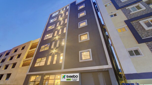 A modern multi-story building with a sign for 'treebo trend' indicating a hotel or accommodation. - Treebo De Alphabet Kondapur (Hyderabad)