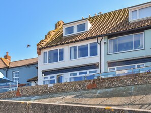 A two-story building with a tiled roof and multiple windows. - 1 bedroom accommodation in Sheringham (Sheringham)