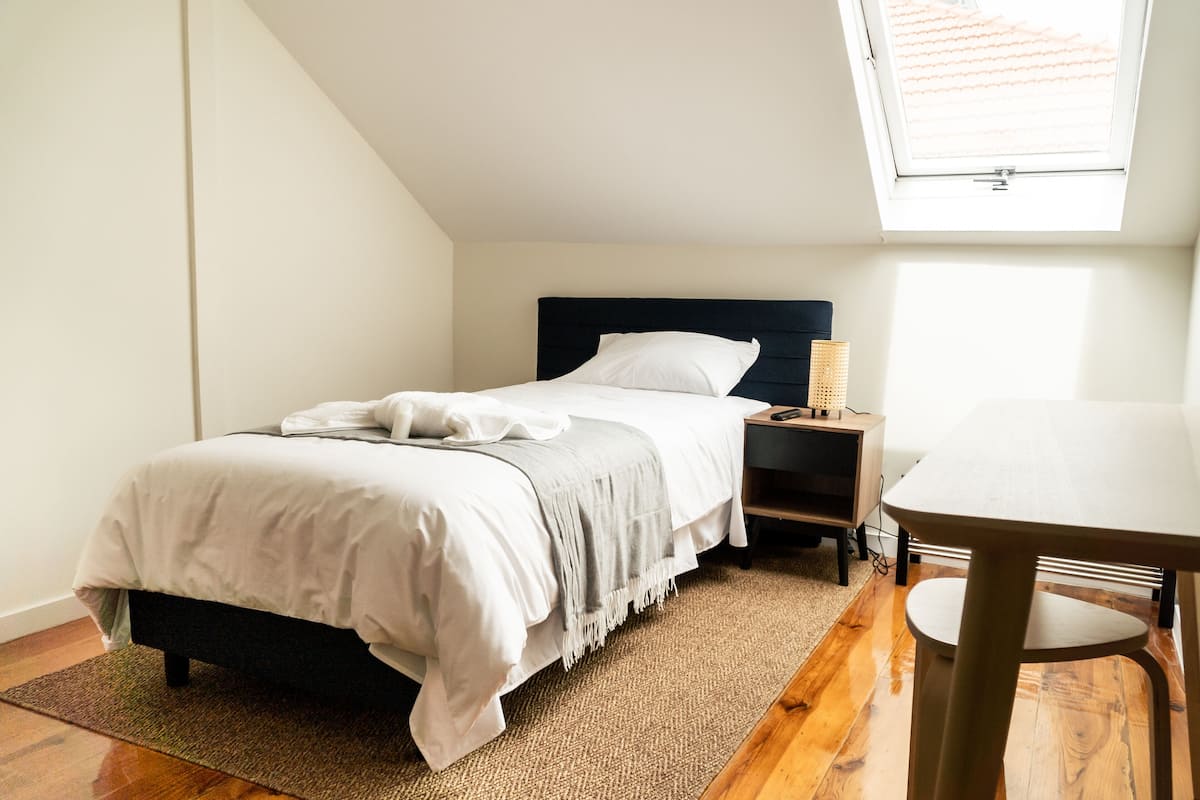 Ein Schlafzimmer mit Bett, Nachttisch und kleinem Tisch.