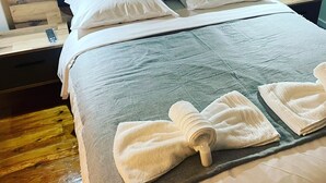 Un lit bien fait, avec des draps blancs et des serviettes soigneusement pliées posées sur le lit.