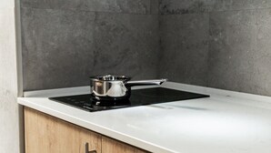 Une cuisine dotée d’une plaque de cuisson à induction noire et d’une casserole en acier inoxydable.