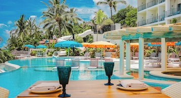 Una piscina al aire libre, sombrillas, sillones reclinables de piscina