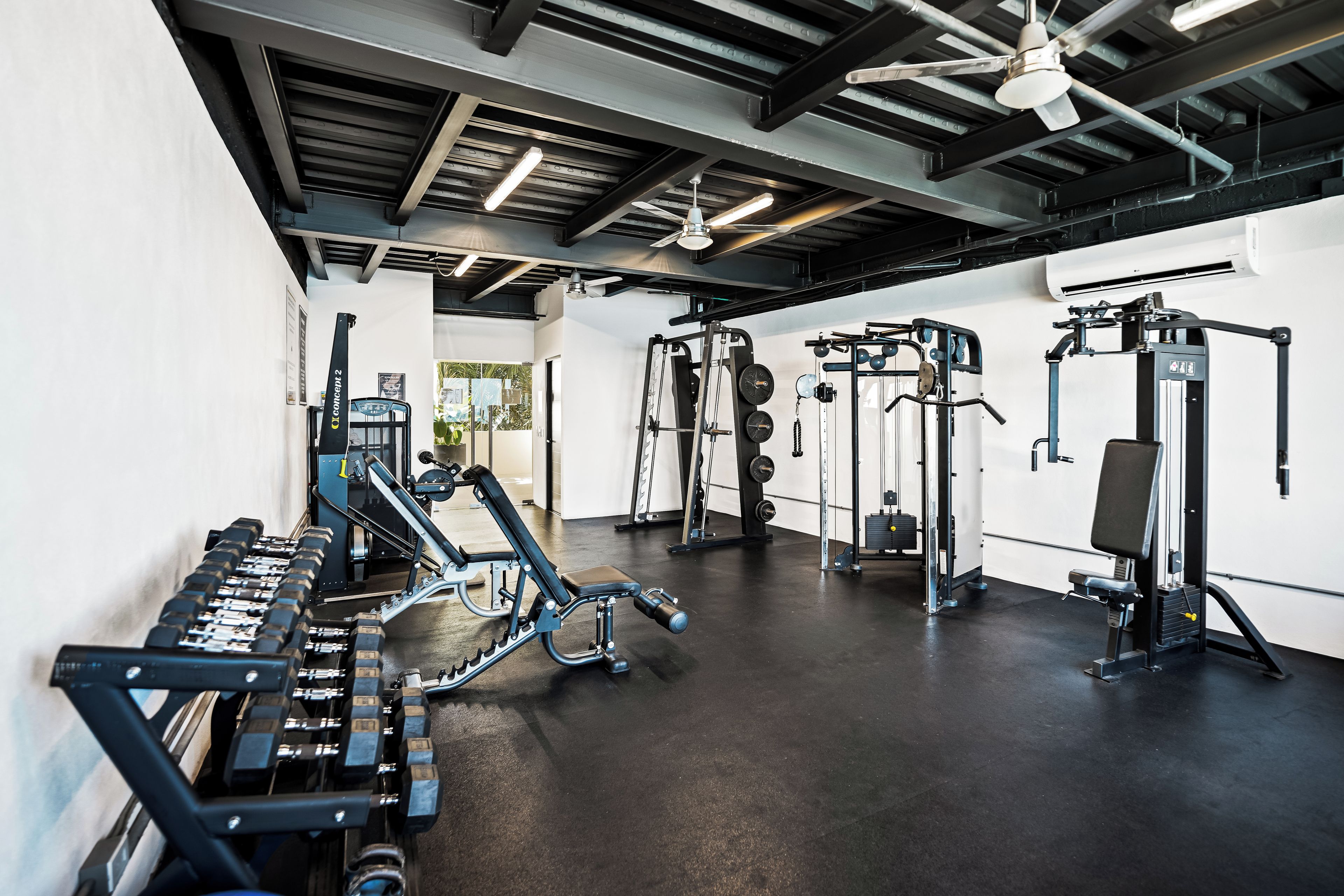 Un gimnasio con diversos equipos de ejercicio, incluyendo máquinas de pesas y pesas libres.