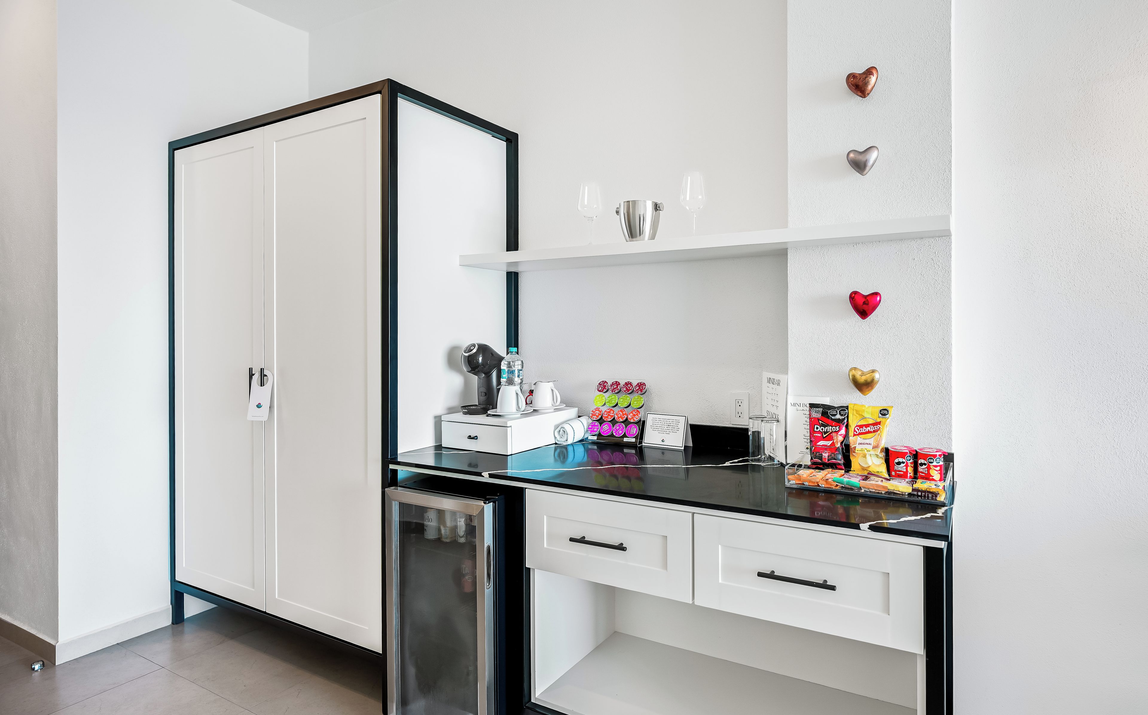 Eine moderne Küche mit schwarzem Arbeitsplatz, weißen Schränken und einer Kaffeemaschine.